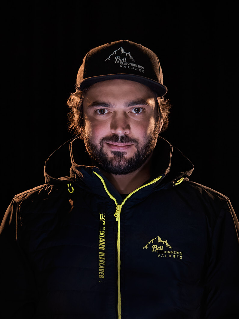 Mann med caps og svart jakke