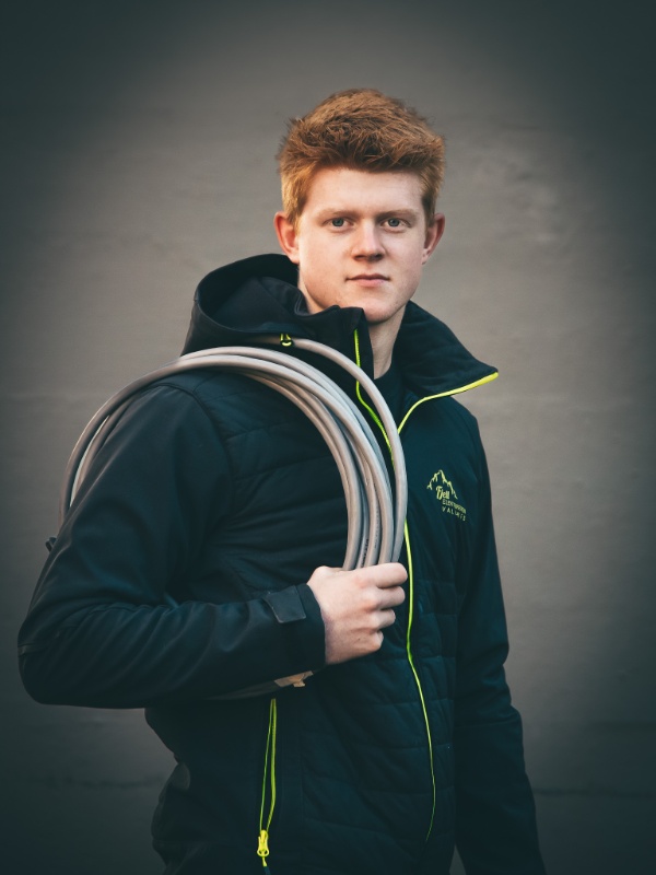 Mann med brunt hår og svart jakke